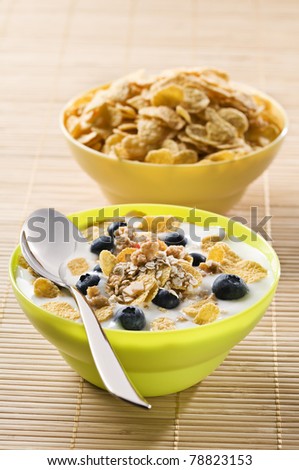 Corn flakes with blue berries and milk close up
