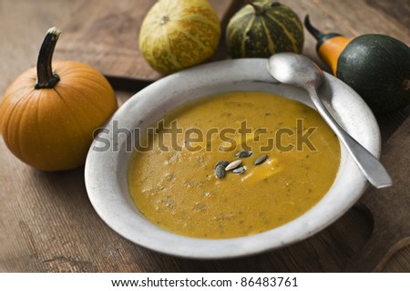 Fresh pumpkin soup on wooden table close up