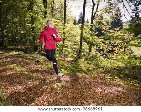 Young woman running in forest close up