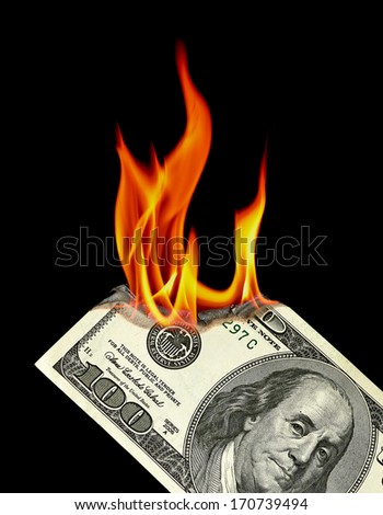 Dollar bill burning on black background