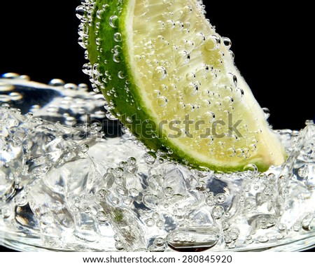 Cocktail glass with lime slices and ice cubes isolated on white background