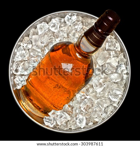Whiskey bottle in ice bucket top view on black background including clipping path