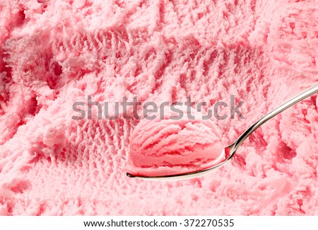 Spoon of strawberry ice cream on  ice cream background