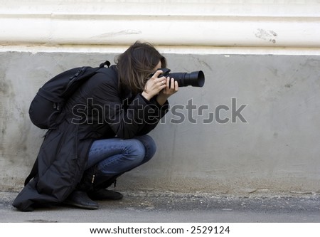 Photographer taking a shoot with a digital camera and a telephoto lens