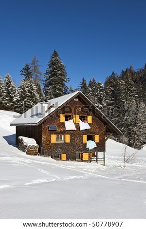 Winter vacation - Rural sunny winter landscape with occupied chalet.