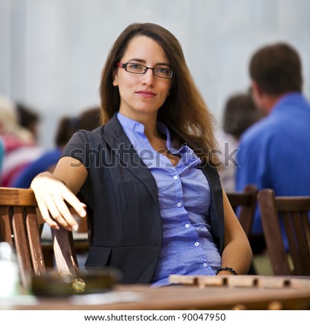 Pretty young woman sitting in a garden restaurants and enjoys her break from work.