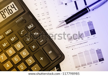 Pen and calculator over annual report