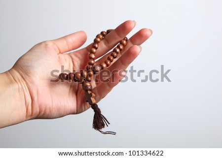 A gentle woman\'s hand holding a rosary