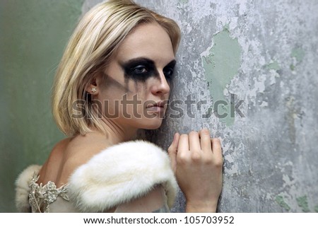 Beautiful young blond girl dressed like a sad gothic bride.