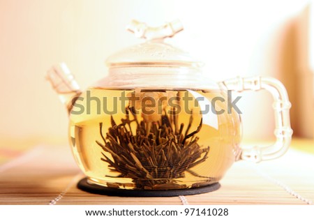 Chinese blooming tea with a jasmin flower in a glass teapot