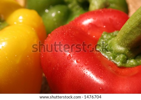 Three capsicum peppers red, green yellow with shallow depth of field