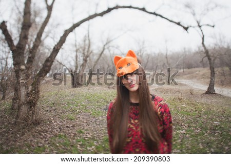 woman in mask of a fox, in the park