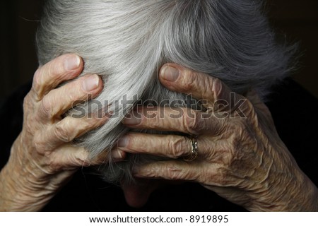 grayed haired lady holding head in severe pain