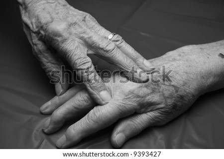 two elderly hands touching