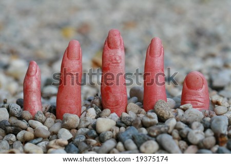 fingers pointing out of rocks making this a scary halloween picture