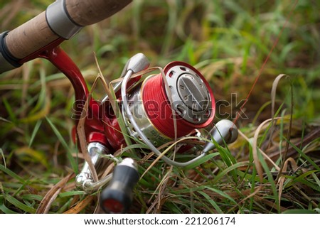 Fishing reel with setup for predator fish casting (angling) like pike, perch, zander etc. Location: river coast, on the ground