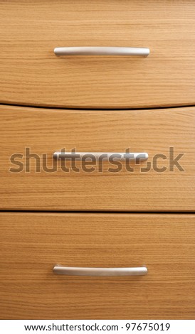 Oak cabinet background.  Detail of wooden chest of drawers in a modern room