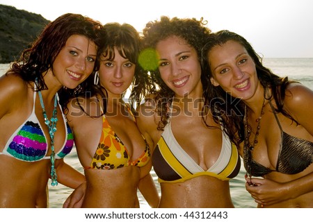 Four gorgeous young girls relaxing by the ocean during a hot summers day in Malta in their bikinis.