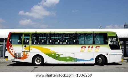 Tour bus in white with red, yellow, green and blue pattern