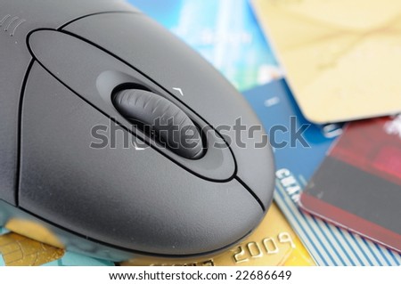 Closeup of wireless mouse over credit card background