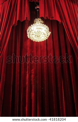 Crystal chandelier with theater stage red curtains