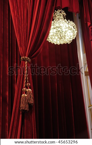 Crystal chandelier with theater stage red curtains