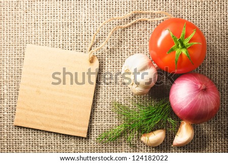 tomato onion and garlic vegetables and price tag on sacking background texture