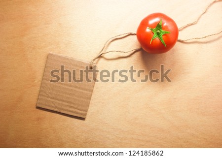 tomato vegetable and price tag on wood background texture