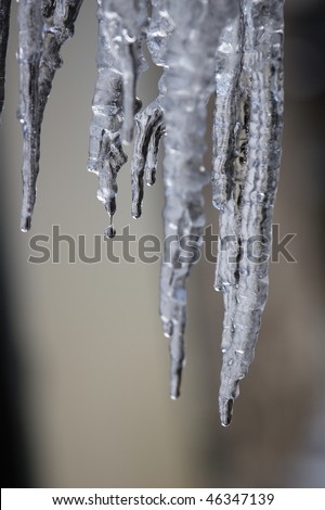 Sparkling icicle hanging down with water-drop