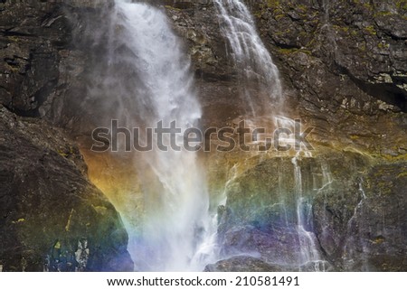 Sun rays which  meet on the fine dust of the waterfall that shine in the glorious colors of the rainbow