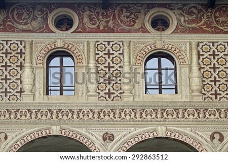 Vigevano - Detail view of a Renaissance palace with sand-colored facades and eggplant-colored paintings