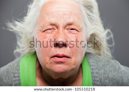 Senior woman white grey hair with expressive emotional face and hands. Studio shot isolated on grey background.