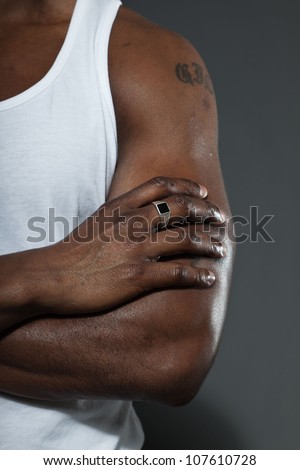 Muscled arm of black american man. Studio shot isolated on grey background.