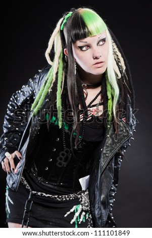 Cyber punk girl with green blond hair and red eyes isolated on black background. Expressive face. Studio shot.