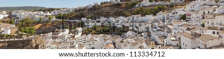 Panoramic photo overviewing pueblo blanco Setenil de las Bodegas. Old white village. Blue sky. Cadiz. Andalusia. Spain.