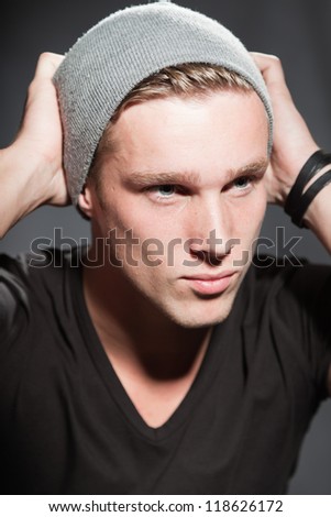 Winter fashion studio portrait of urban young man wearing woolen hat.