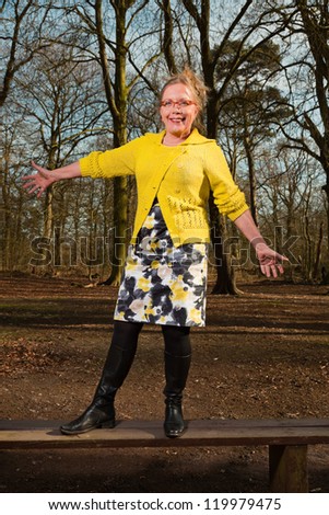 Happy healthy senior woman enjoying nature in forest.