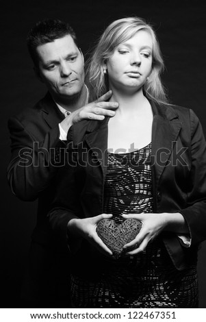Mysterious couple in love. Studio shot against black.