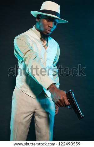 Black american mafia gangster man in suit with pistol.