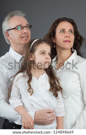 Happy family of father, mother and daughter. Studio shot.