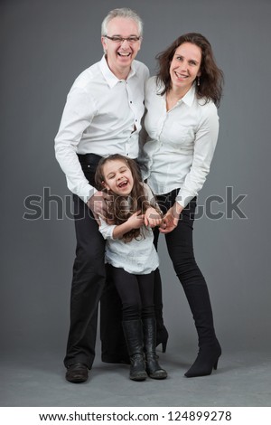 Happy family of father, mother and daughter. Studio shot.