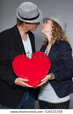 Young couple in love holding big red heart. Man and woman.