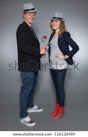 Young couple in love holding red rose. Man and woman.