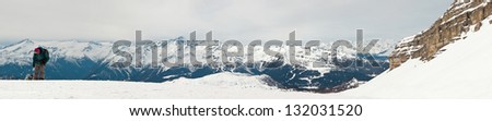 Panorama of winter sport snow mountain landscape with ski tourists.