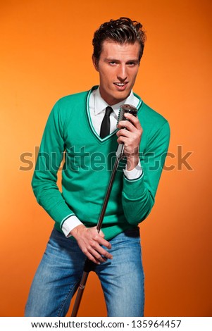 Retro fifties style rock and roll singer with green shirt. Studio shot.