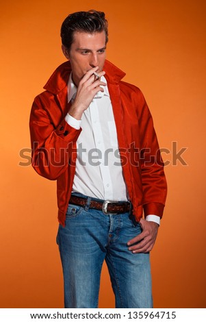 Vintage fashion fifties man smoking cigarette. Rebel look. Studio shot.