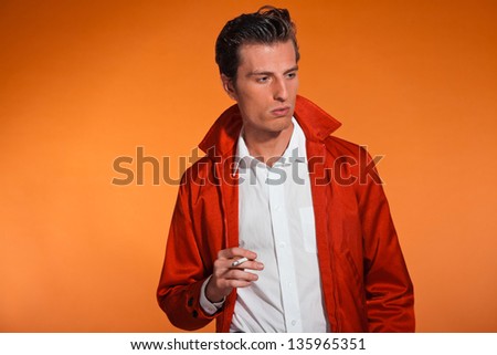 Vintage fashion fifties man smoking cigarette. Rebel look. Studio shot.