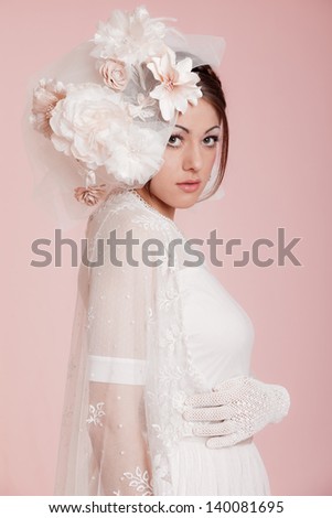 Vintage romantic bride with long hair in white wedding dress. Decorated with flowers.