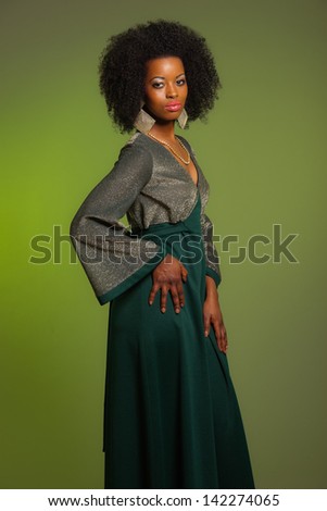 Sensual retro seventies fashion afro woman with green dress. Green background.