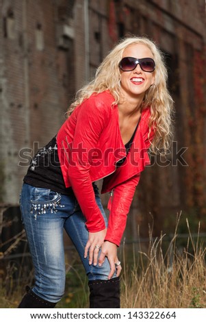Pretty young woman with long blonde hair and black sunglasses. Urban fashion.
